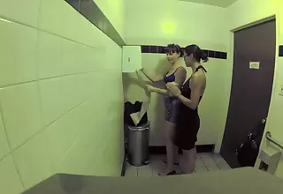 Duo bitches are with the public bathroom, licking one another